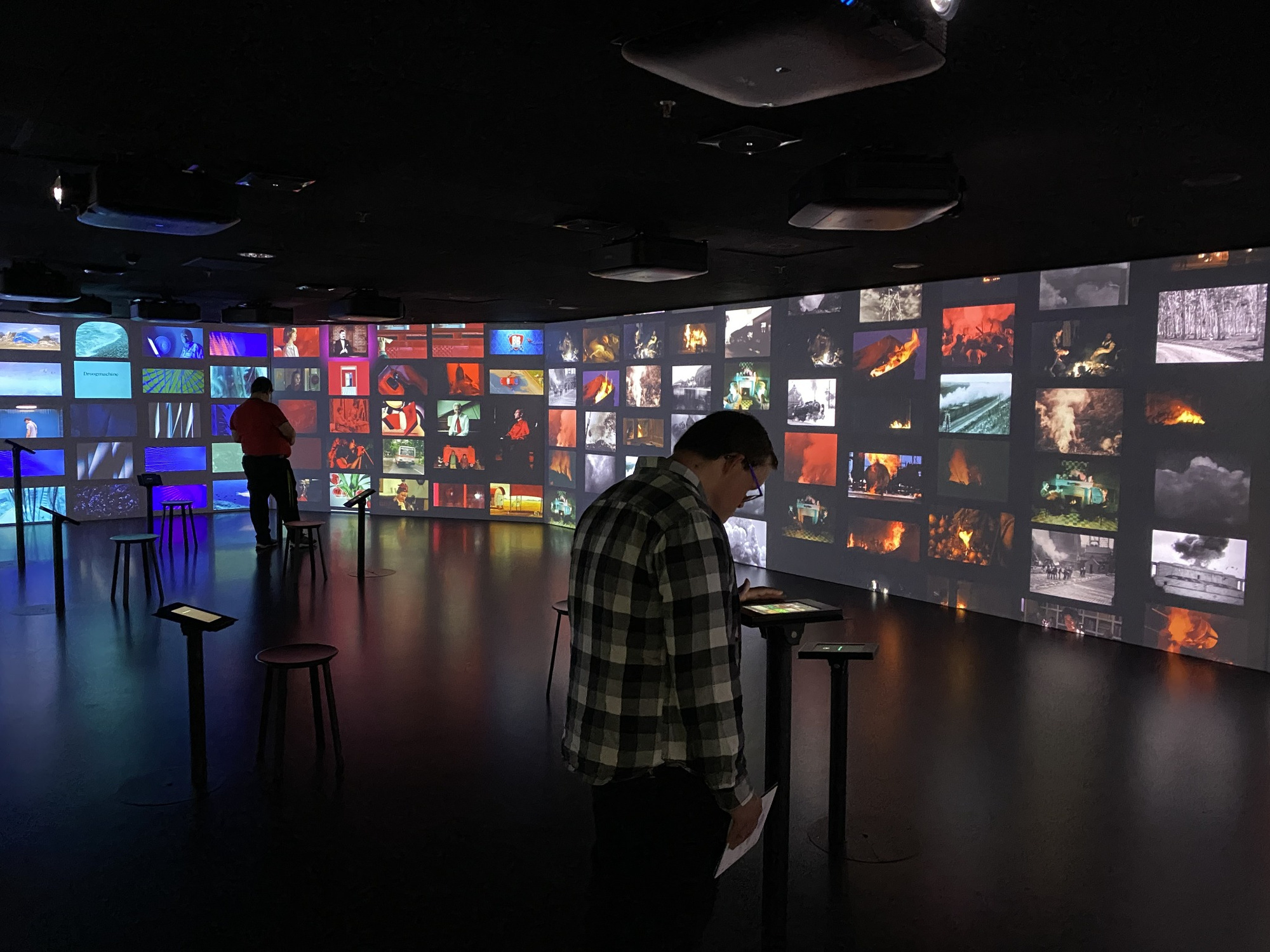 In een donkere zaal zijn heel veel filmbeelden te zien. Bezoekers kunnen rustig rondkijken en zelf dingen ontdekken.